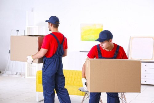 Furniture pick-up team handling a bulky sofa in a London flat